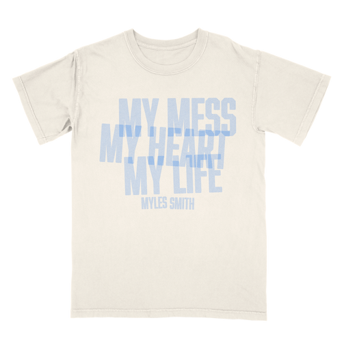 Front view of an ivory unisex short-sleeve T-shirt with blue text across the front reading ‘My Mess, My Heart, My Life,’ and smaller text below reading ‘Myles Smith.